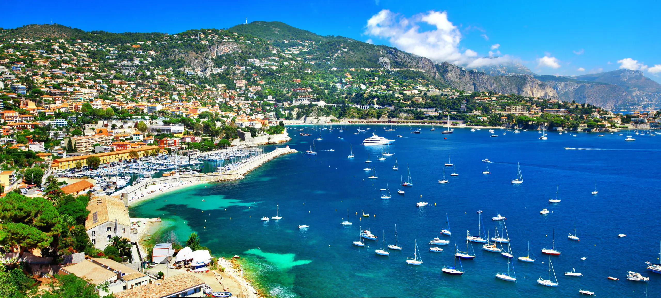 Panoramic view of Nice, French Riviera. Wide landscape of Promenade des Anglais, Baie des Anges and turquoise Mediterranean sea at sunny day. Azure coast of France.