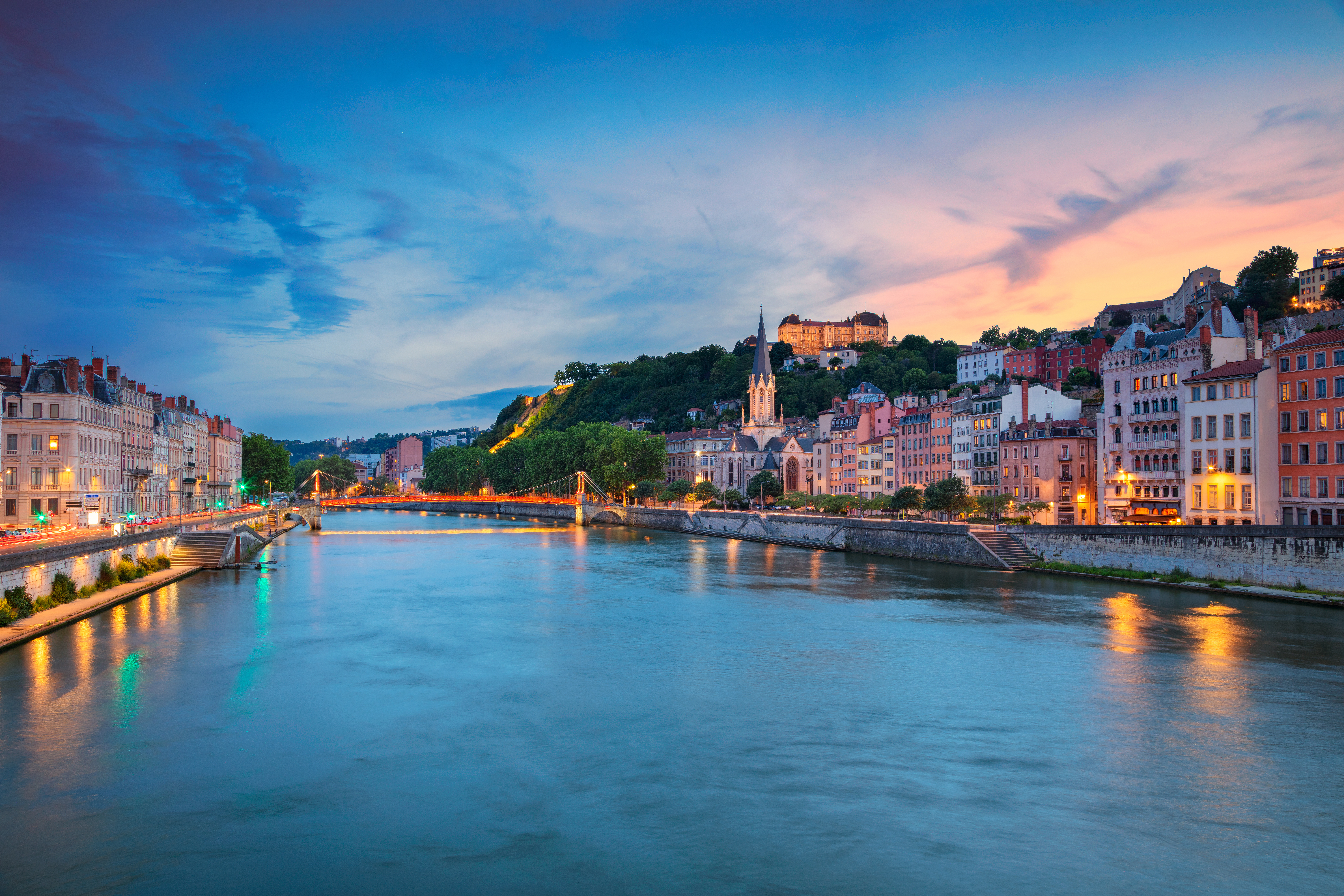 Lyon. Cityscape image of Lyon, France during sunset. Vienne’s ancient Roman theatre with semicircular stone seating and a covered stage, overlooking terracotta rooftops and the Rhône River.